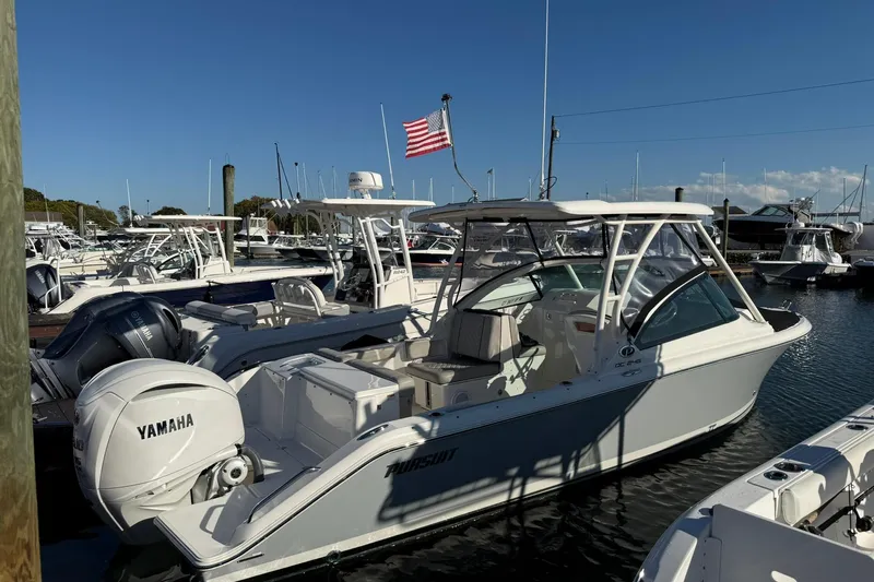  Yacht Photos Pics 2024 Pursuit DC 246 Dual Console boat docked with Yamaha engine, clear sky background.