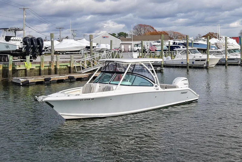  Yacht Photos Pics 2024 Pursuit DC 246 Dual Console boat docked in a marina with other vessels.