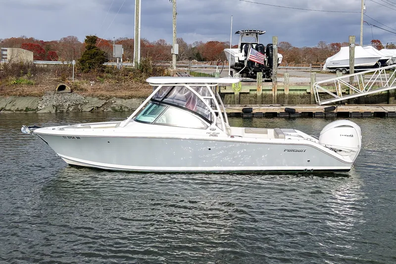  Yacht Photos Pics 2024 Pursuit DC 246 Dual Console boat on water, docked near a marina.