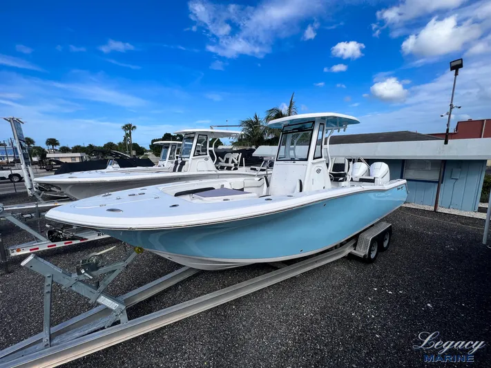  Yacht Photos Pics 2024 Tidewater 272 CC Adventure boat on trailer under blue sky.