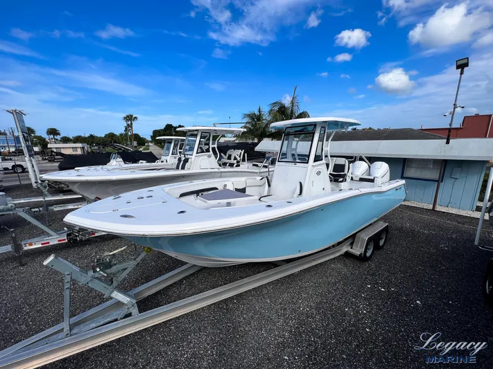  Yacht Photos Pics 2024 Tidewater 272 CC Adventure boat on trailer under blue sky.