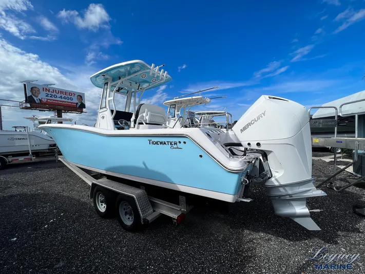  Yacht Photos Pics 2024 Tidewater 272 CC Adventure boat on trailer, featuring Mercury engine, under blue sky.