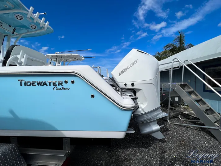  Yacht Photos Pics 2024 Tidewater 272 CC Adventure boat with Mercury engine, blue hull, parked outdoors.