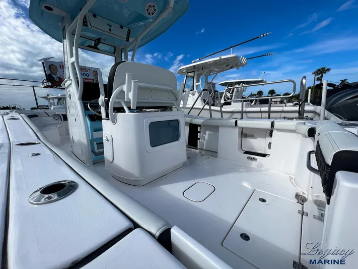  Yacht Photos Pics 2024 Tidewater 272 CC Adventure boat interior with seating and fishing equipment under a blue sky.