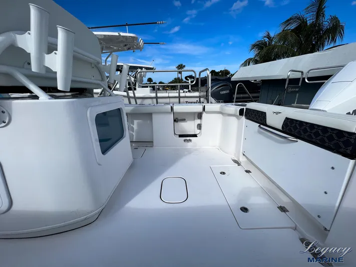  Yacht Photos Pics 2024 Tidewater 272 CC Adventure boat deck with seating and storage under a clear blue sky.