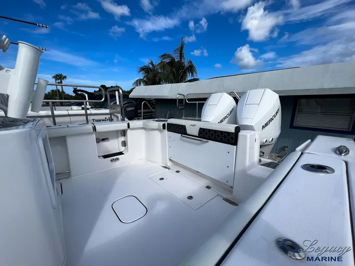  Yacht Photos Pics 2024 Tidewater 272 CC Adventure boat with dual Mercury engines, spacious deck, and clear blue sky.