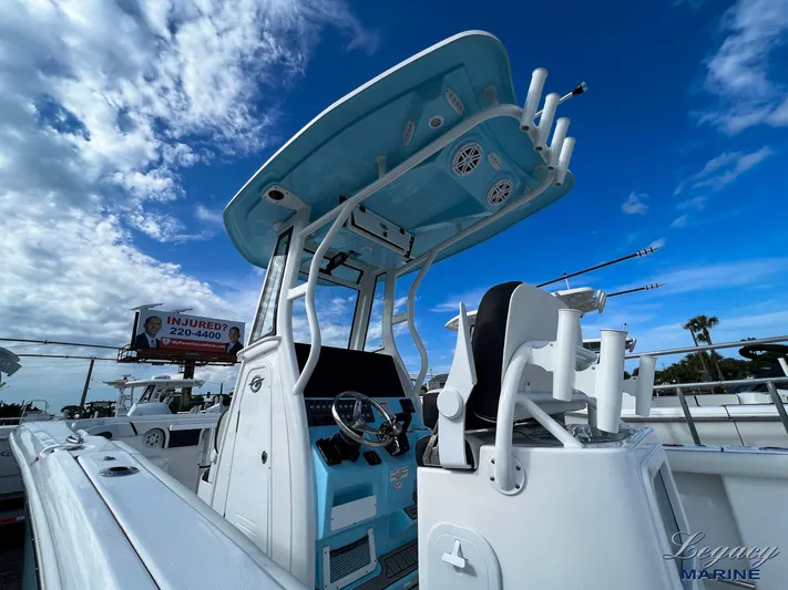  Yacht Photos Pics 2024 Tidewater 272 CC Adventure boat with blue T-top under a partly cloudy sky.
