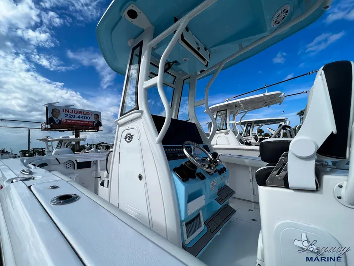  Yacht Photos Pics 2024 Tidewater 272 CC Adventure boat with sleek design and modern console, under a blue sky.