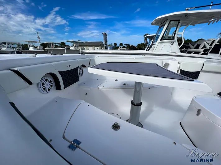  Yacht Photos Pics 2024 Tidewater 272 CC Adventure boat interior with seating and table under a clear blue sky.