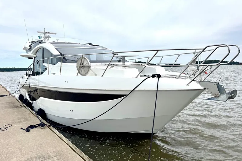 Yacht Photos Pics 2018 Galeon 470 Skydeck yacht docked by the water on a cloudy day.