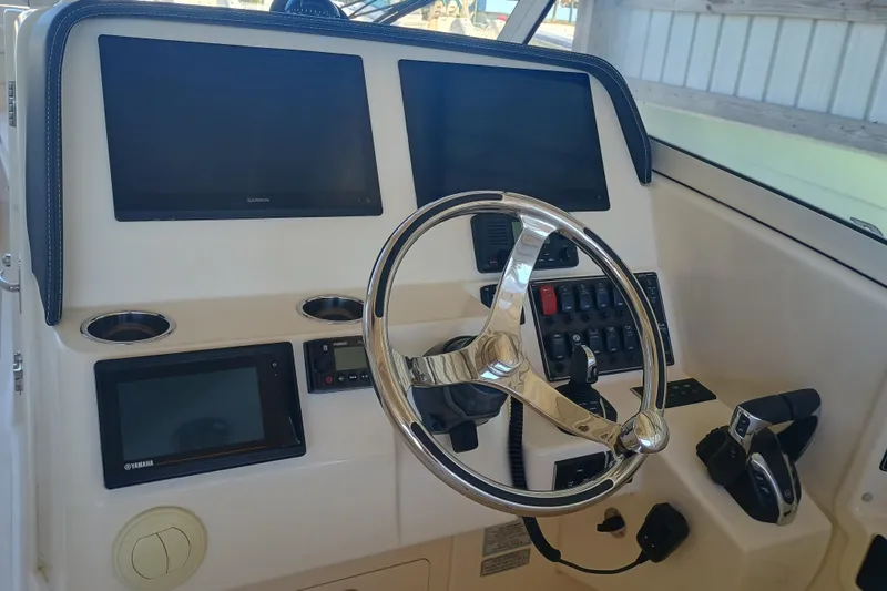 325-708 Brokerage Josh Yacht Photos Pics Control panel of 2021 Grady-White Freedom 325 boat with steering wheel and displays.