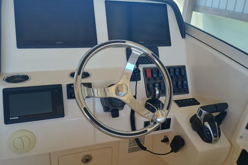325-708 Brokerage Josh Yacht Photos Pics Control panel of 2021 Grady-White Freedom 325 boat with steering wheel and electronic displays.