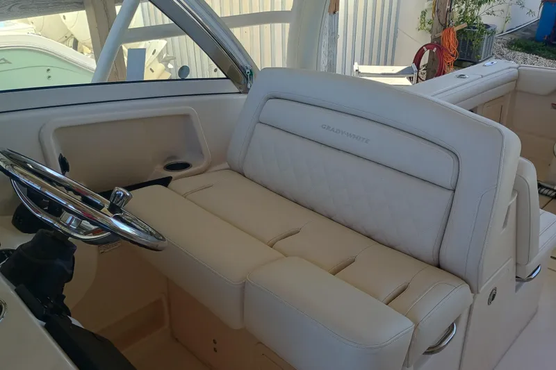 325-708 Brokerage Josh Yacht Photos Pics 2021 Grady-White Freedom 325 boat interior with beige seating and steering wheel.