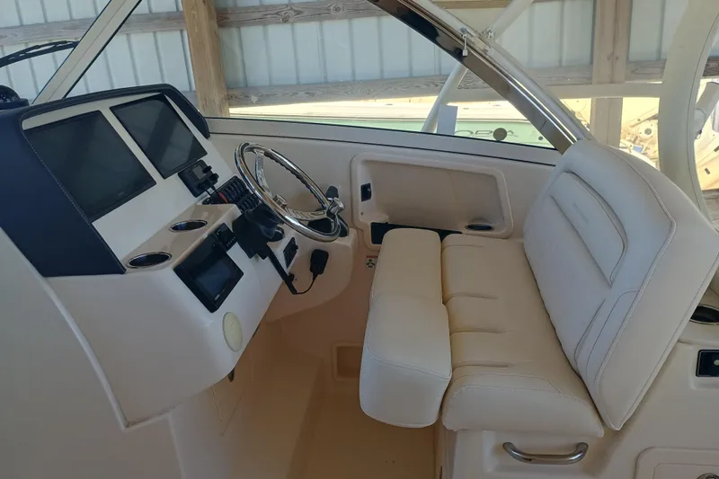 325-708 Brokerage Josh Yacht Photos Pics 2021 Grady-White Freedom 325 boat interior with steering wheel and seating.