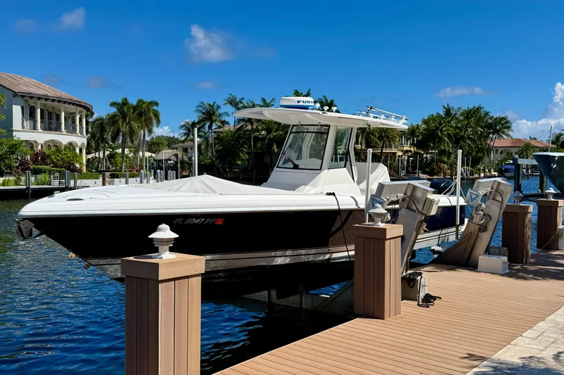  Yacht Photos Pics 2014 Intrepid 327 Center Console boat docked by waterfront homes, under clear blue skies.