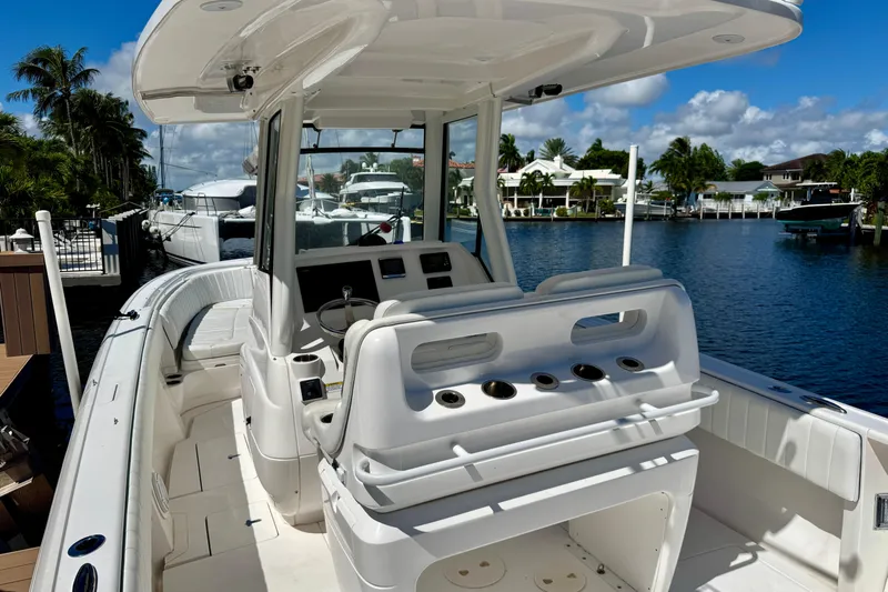  Yacht Photos Pics 2014 Intrepid 327 Center Console boat docked by waterfront homes under blue sky.