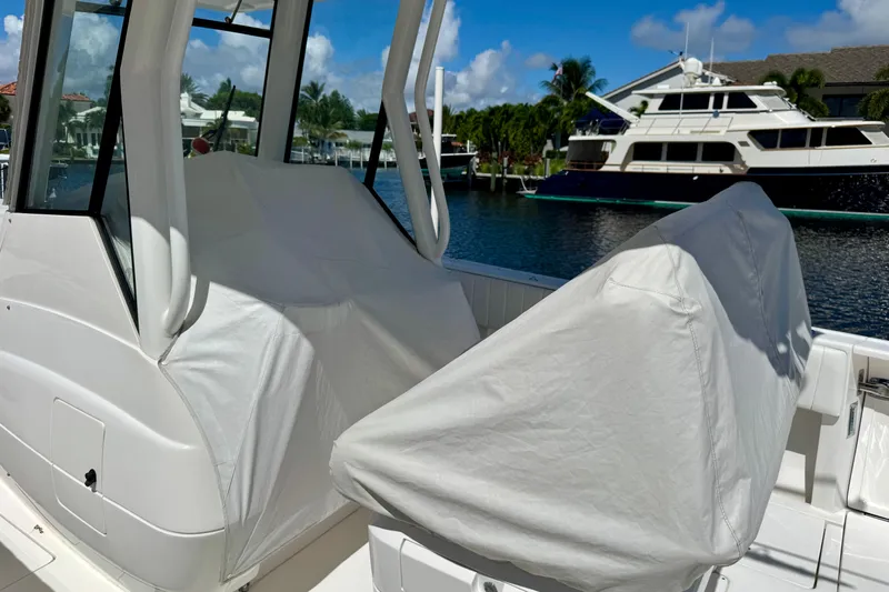  Yacht Photos Pics 2014 Intrepid 327 Center Console boat with covered seats, docked near luxury yachts.