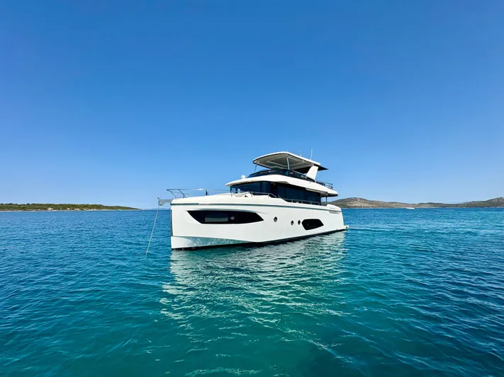  Yacht Photos Pics 2024 Absolute NAVETTA 52 yacht on clear blue water under a bright sky.