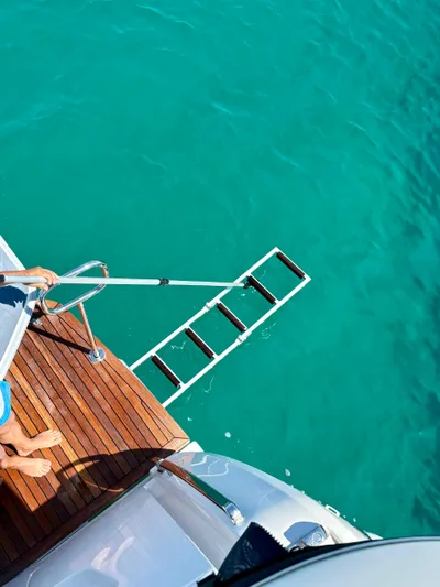  Yacht Photos Pics Luxury yacht Absolute NAVETTA 52, 2024 model, with swim ladder over turquoise water.