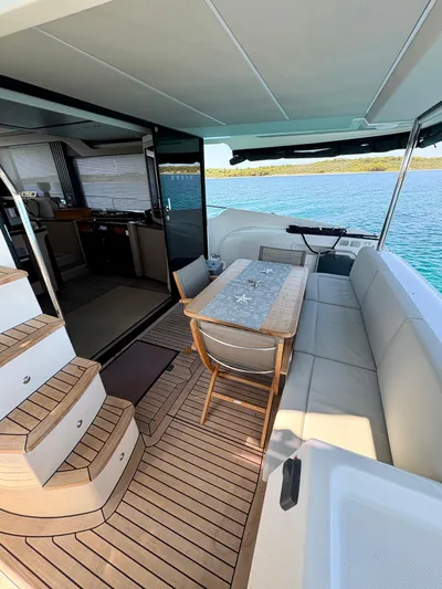  Yacht Photos Pics 2024 Absolute NAVETTA 52 yacht interior with elegant seating and dining area, overlooking serene waters.