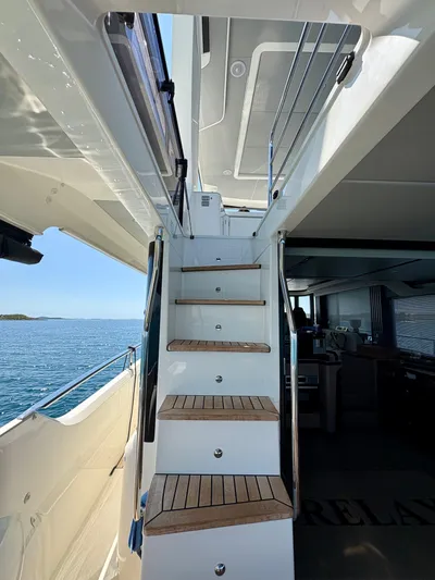 Yacht Photos Pics Staircase on 2024 Absolute NAVETTA 52 yacht, leading to upper deck with ocean view.