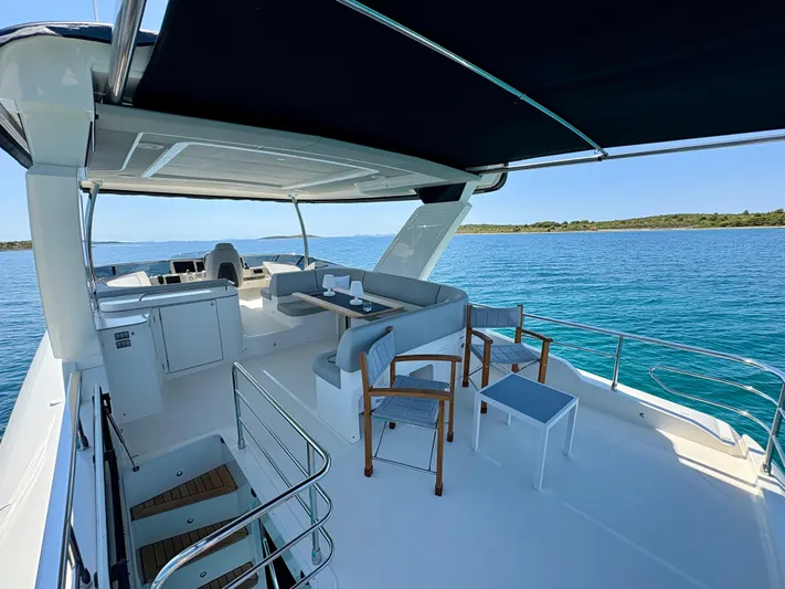  Yacht Photos Pics Luxurious 2024 Absolute NAVETTA 52 yacht deck with seating, overlooking serene blue waters.