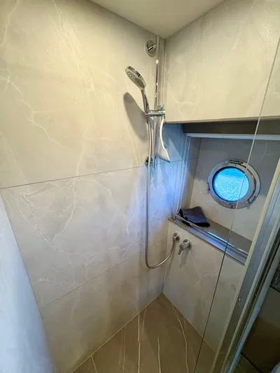  Yacht Photos Pics Luxurious shower area in 2024 Absolute NAVETTA 52 yacht with porthole window.