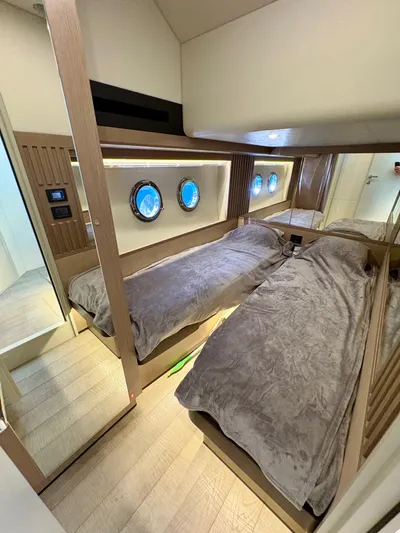  Yacht Photos Pics Luxurious 2024 Absolute NAVETTA 52 yacht cabin with twin beds and porthole windows.