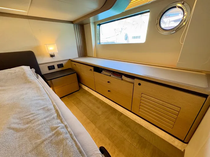  Yacht Photos Pics Luxurious interior of 2024 Absolute NAVETTA 52 yacht with modern wood cabinetry and porthole window.