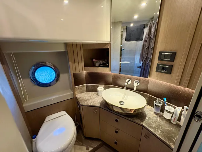  Yacht Photos Pics Luxurious bathroom in 2024 Absolute NAVETTA 52 yacht with modern fixtures and porthole window.