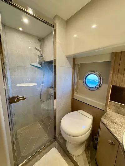  Yacht Photos Pics Luxurious bathroom on 2024 Absolute NAVETTA 52 yacht with shower and porthole window.