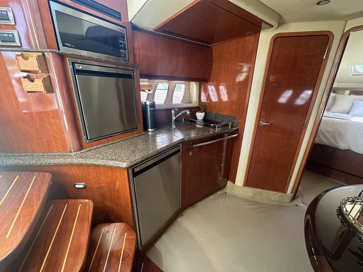 Salty Dawg Yacht Photos Pics Luxurious 2006 Sea Ray 380 Sundancer yacht interior with modern kitchen and cozy bedroom.