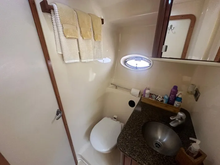 Salty Dawg Yacht Photos Pics Compact bathroom in 2006 Sea Ray 380 Sundancer yacht with sink, toilet, and porthole window.