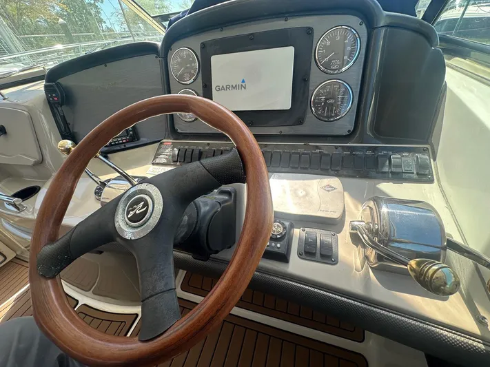 Salty Dawg Yacht Photos Pics Helm of 2006 Sea Ray 380 Sundancer with Garmin navigation system and wooden steering wheel.