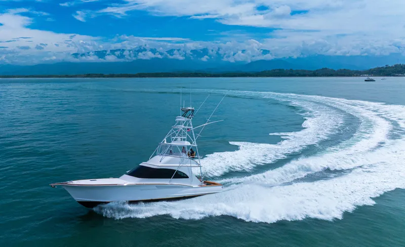  Yacht Photos Pics 2022 Jarrett Bay Flybridge Express cruising on open water with scenic coastal backdrop.