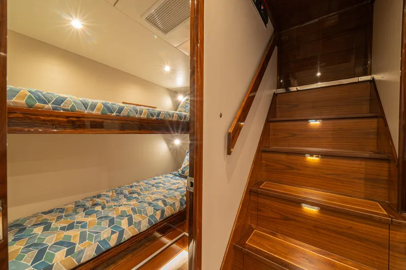  Yacht Photos Pics 2022 Jarrett Bay Flybridge Express interior with wooden stairs and cozy bunk beds.