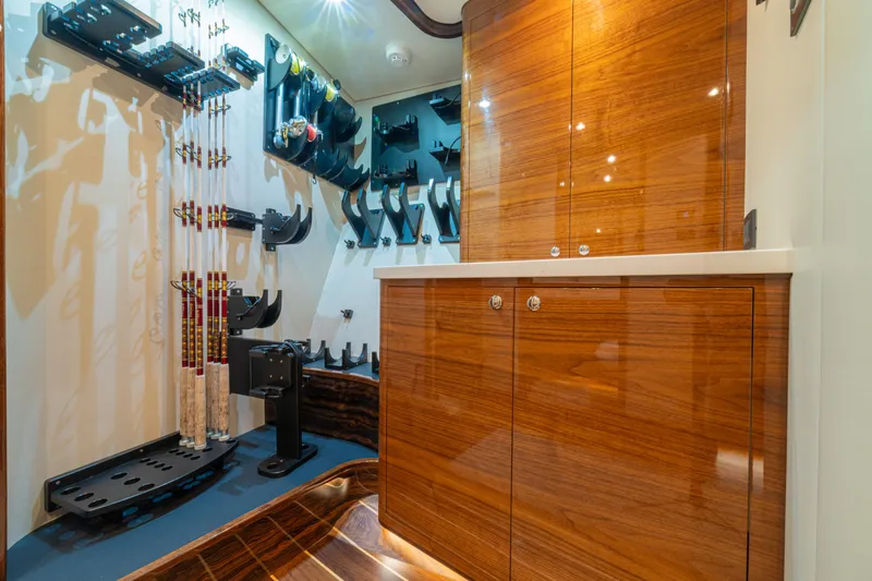  Yacht Photos Pics 2022 Jarrett Bay Flybridge Express interior with fishing rod storage and polished wood cabinetry.