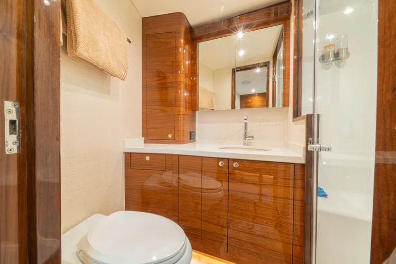  Yacht Photos Pics Luxurious bathroom in 2022 Jarrett Bay Flybridge Express yacht with wood cabinetry and modern fixtures.