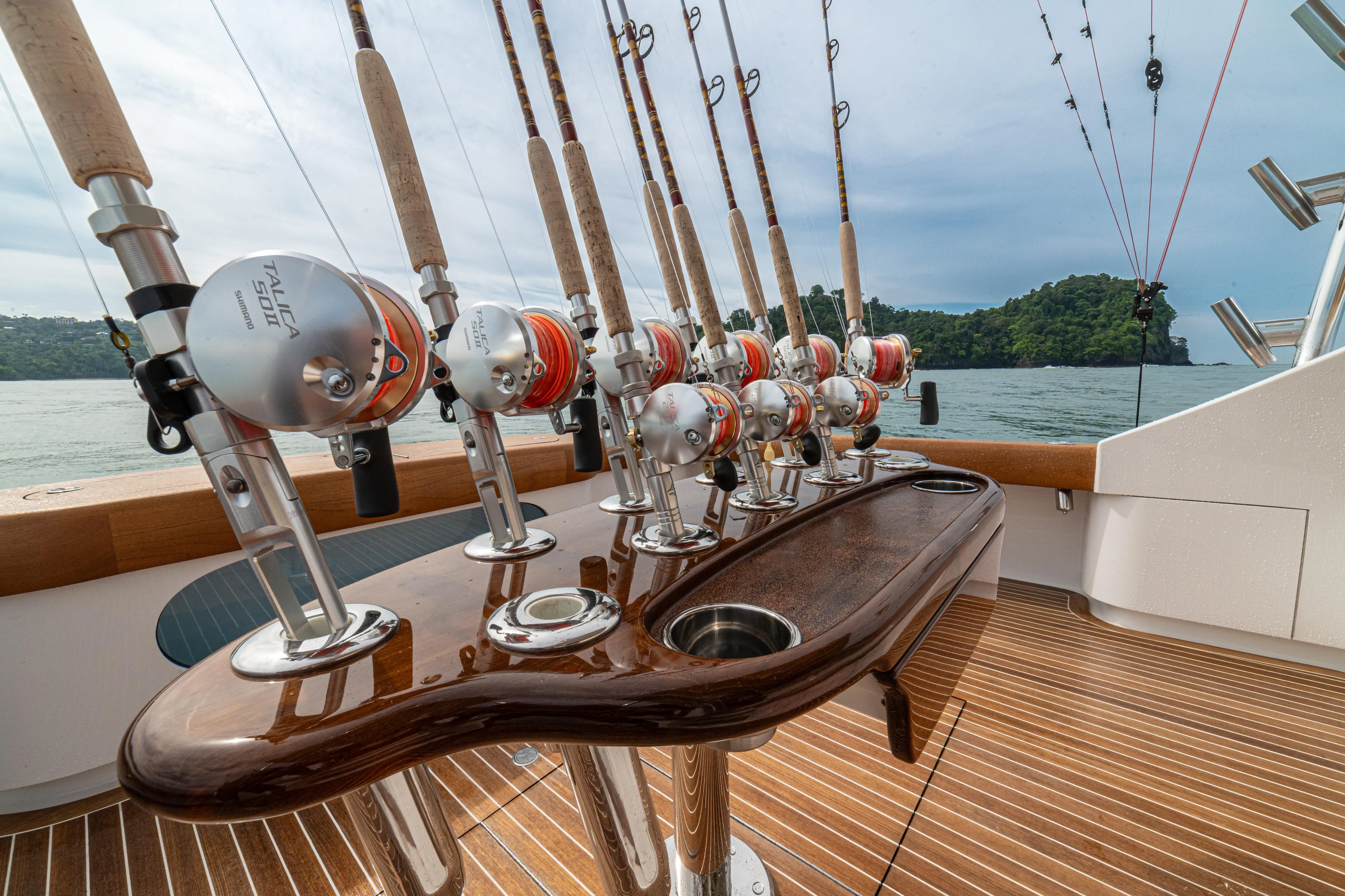  Yacht Photos Pics Fishing rods on a 2022 Jarrett Bay Flybridge Express boat deck, overlooking serene waters.