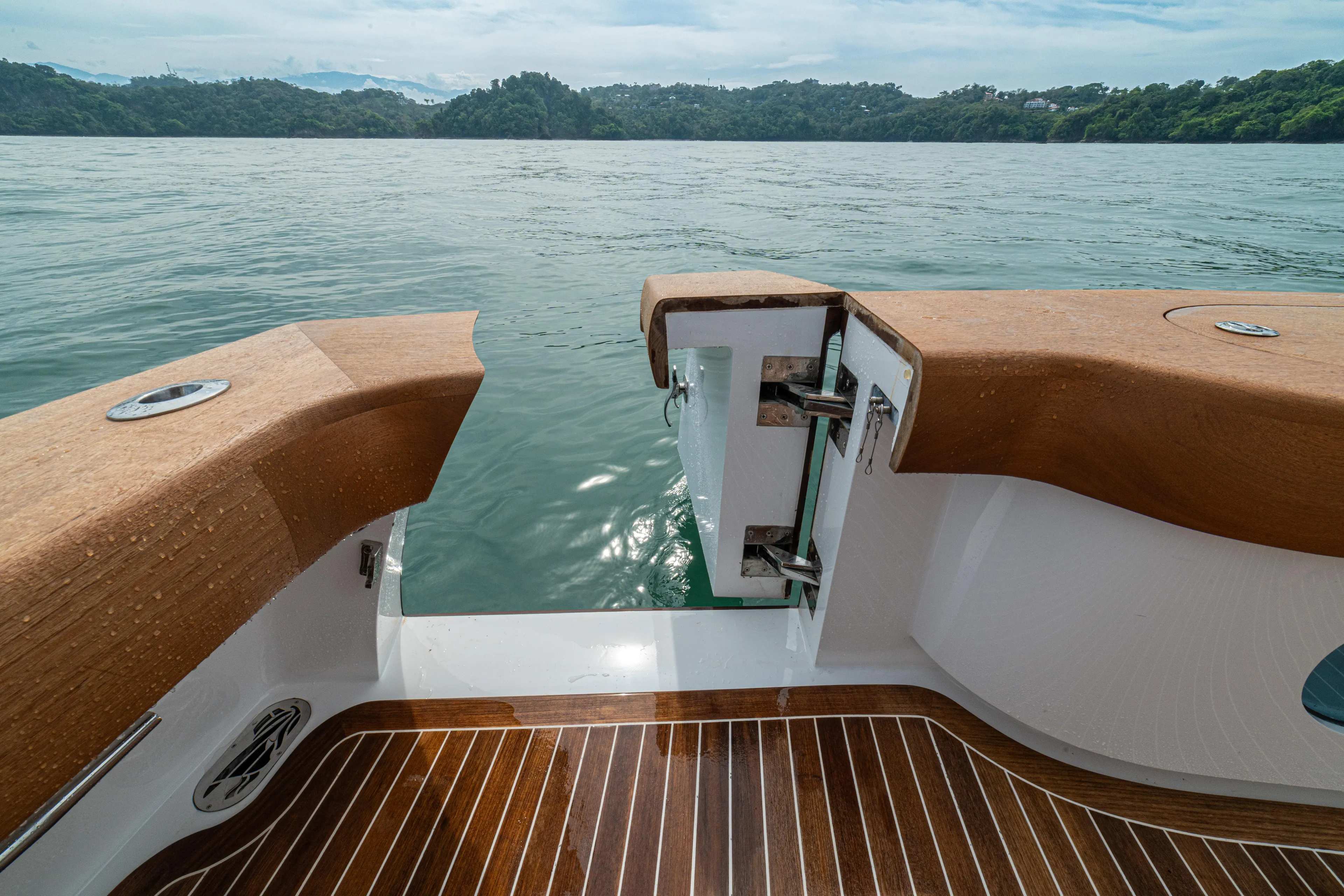  Yacht Photos Pics 2022 Jarrett Bay Flybridge Express boat with open transom, overlooking serene water and lush landscape.