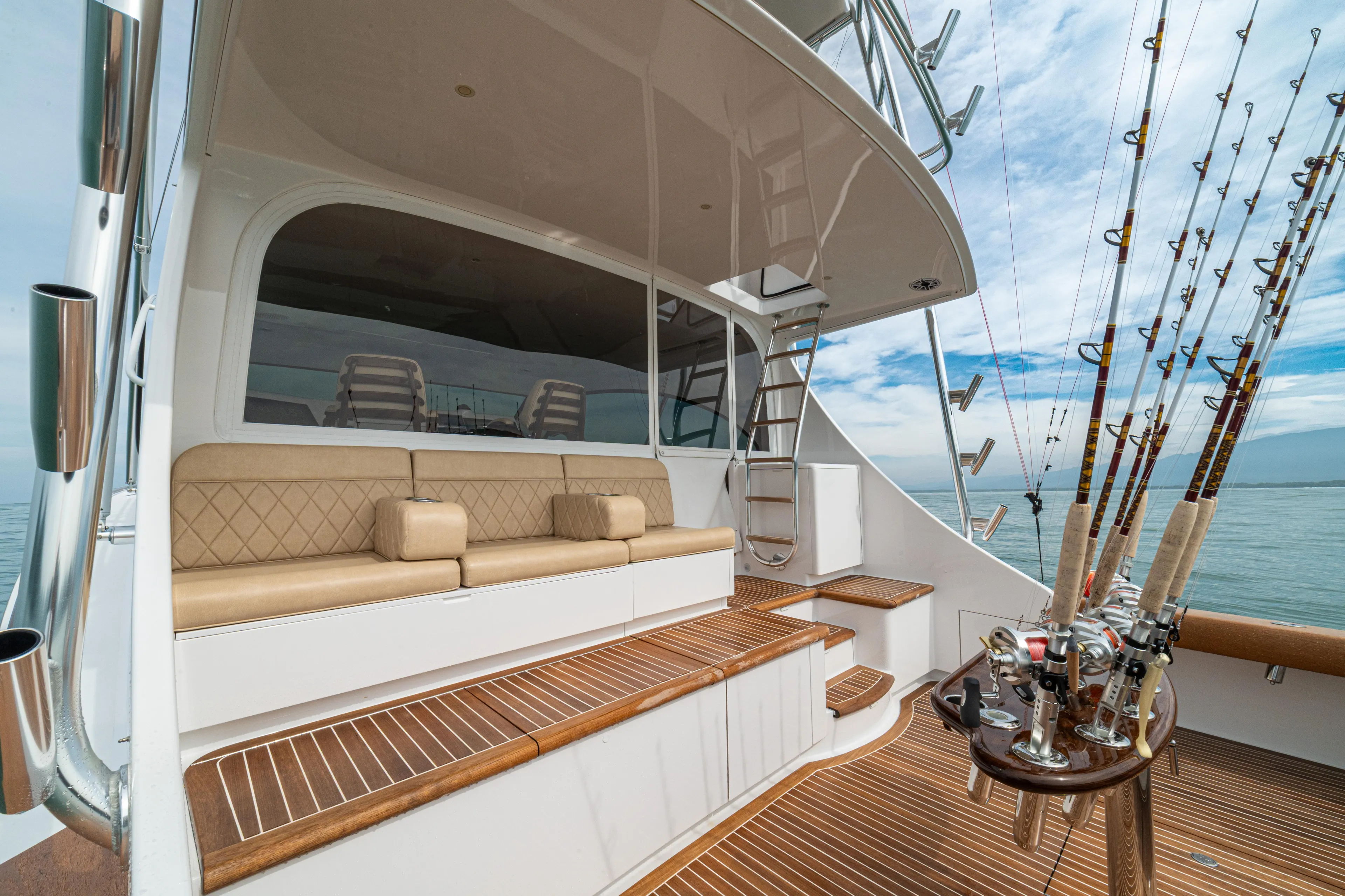  Yacht Photos Pics 2022 Jarrett Bay Flybridge Express yacht with fishing rods and luxurious seating on deck.