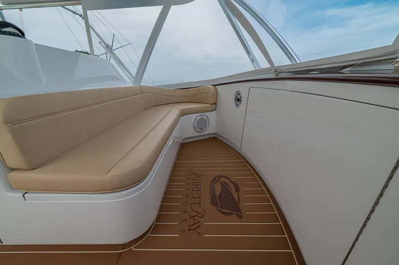  Yacht Photos Pics 2022 Jarrett Bay Flybridge Express with beige seating and teak flooring under a clear sky.