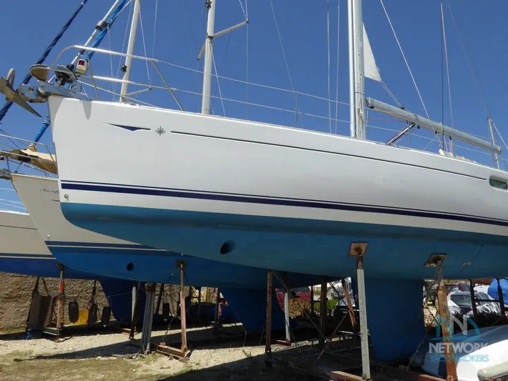  Yacht Photos Pics 2006 Jeanneau Sun Odyssey 49 sailboat on dry dock, blue hull, clear sky background.