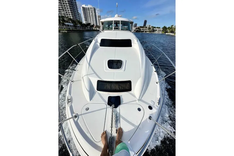  Yacht Photos Pics 2003 Sea Ray 390 Motor Yacht cruising on a sunny day, with cityscape in background.