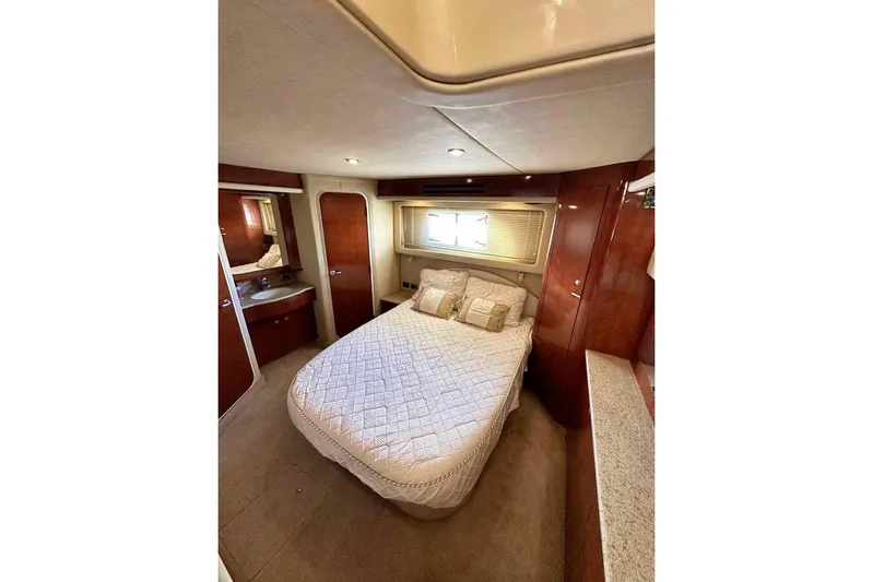  Yacht Photos Pics Luxurious bedroom interior of 2003 Sea Ray 390 Motor Yacht with elegant wood finishes.