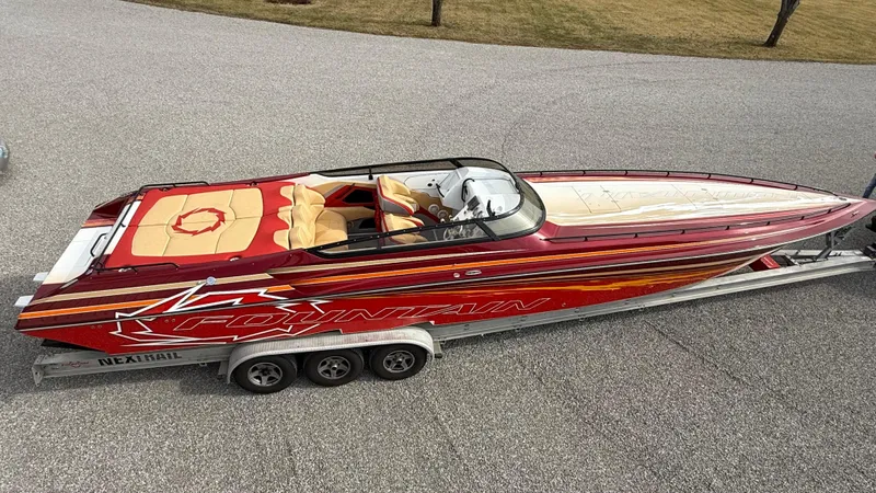  Yacht Photos Pics 2007 Fountain 42 Lightning speedboat on trailer, red and white design, parked on pavement.