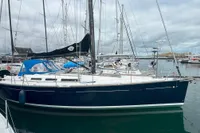 2009 Dufour 45E Performance sailboat docked in a marina under cloudy skies.