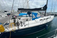 2009 Dufour 45E Performance sailboat docked in marina, featuring sleek design and blue canopy.