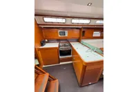 Luxurious 2009 Dufour 45E Performance yacht interior with modern kitchen and wooden cabinetry.