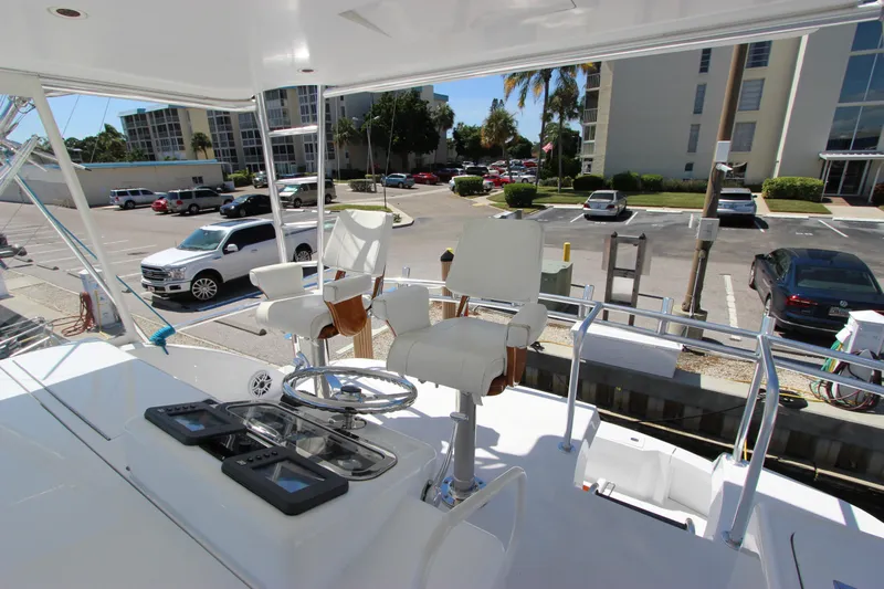  Yacht Photos Pics 2004 Hatteras 60 Convertible yacht helm with seating, docked in a marina parking area.